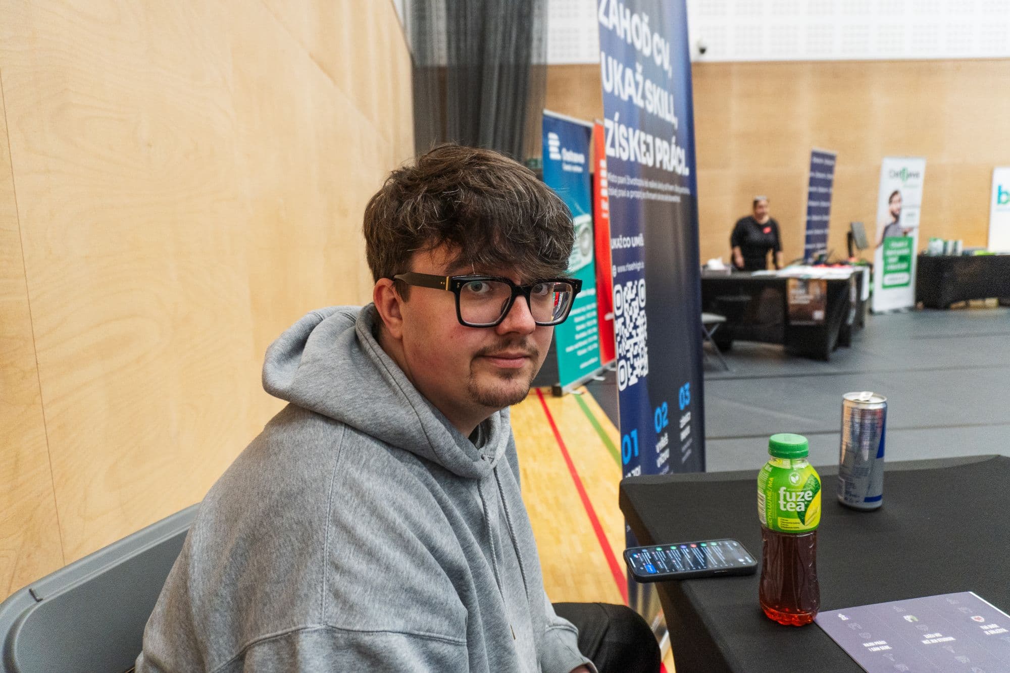 Zdenek, co-founder RiseHigh, v šedé mikině u stánku na veletrhu
